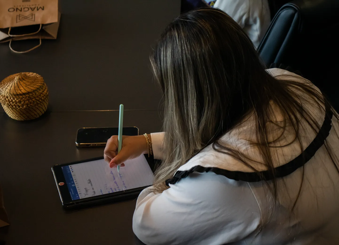 Profissional fazendo anotações em um tablet sobre a mesa
